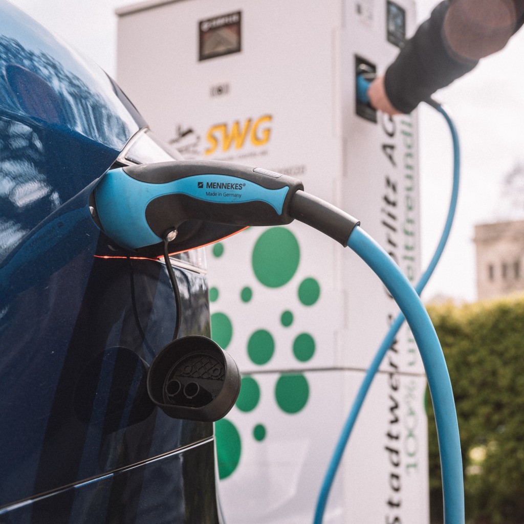 E-Auto wird an der Zapfsäule geladen.