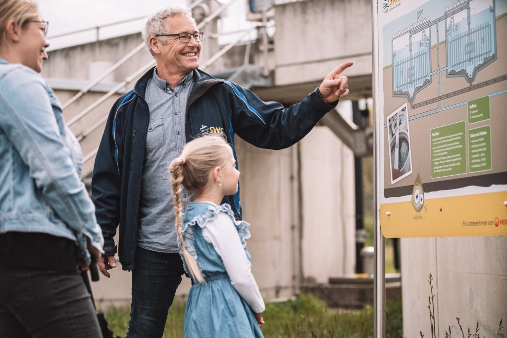 Ein SWG-Mitarbeiter erklärt einer Familie die Anlagen