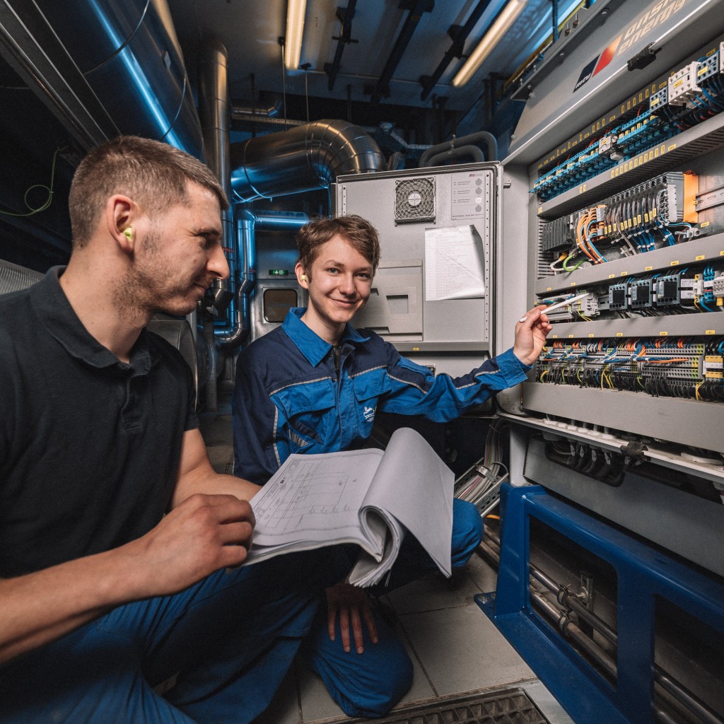 Zwei Mitarbeiter der Stadtwerke Görlitz überprüfen die Anschlüsse in einer Schaltanlage.