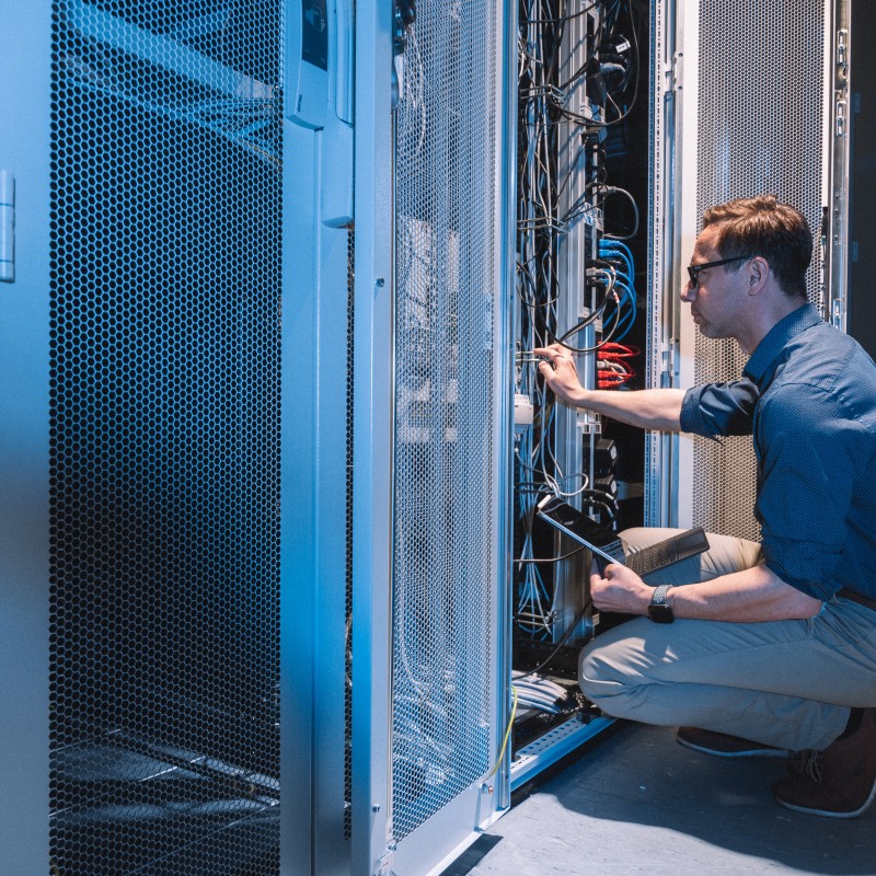 Ein Mitarbeiter der Stadtwerke Görlitz prüft mit einem Laptop einen Schaltschrank – Symbol für IT- und Netzwerktechnik.