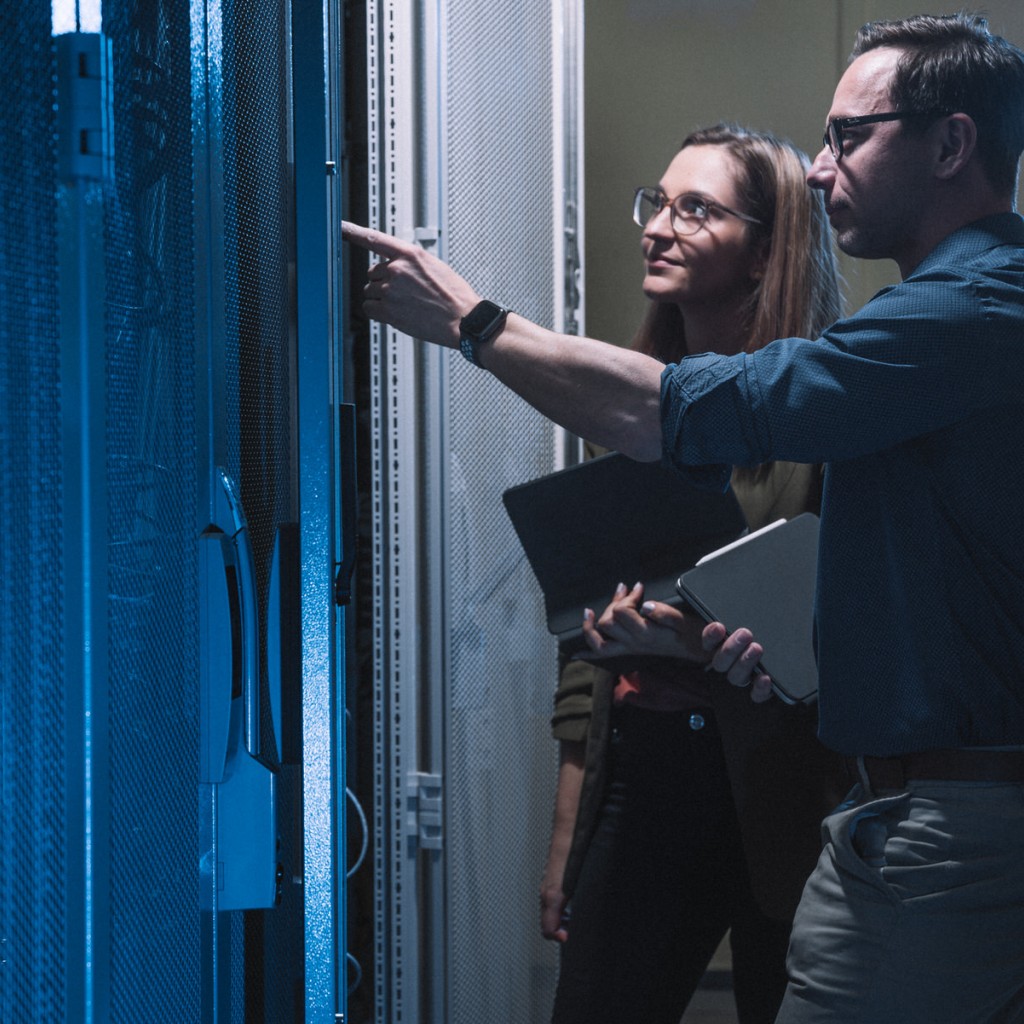 Zwei Mitarbeitende der Stadtwerke Görlitz bei der Überprüfung eines Schaltschrankes mit Tablets.