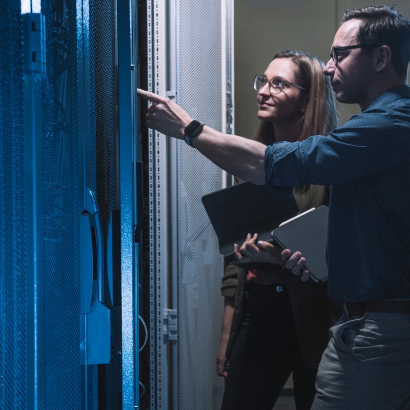 Zwei Mitarbeitende der Stadtwerke Görlitz bei der Überprüfung eines Schaltschrankes mit Tablets.