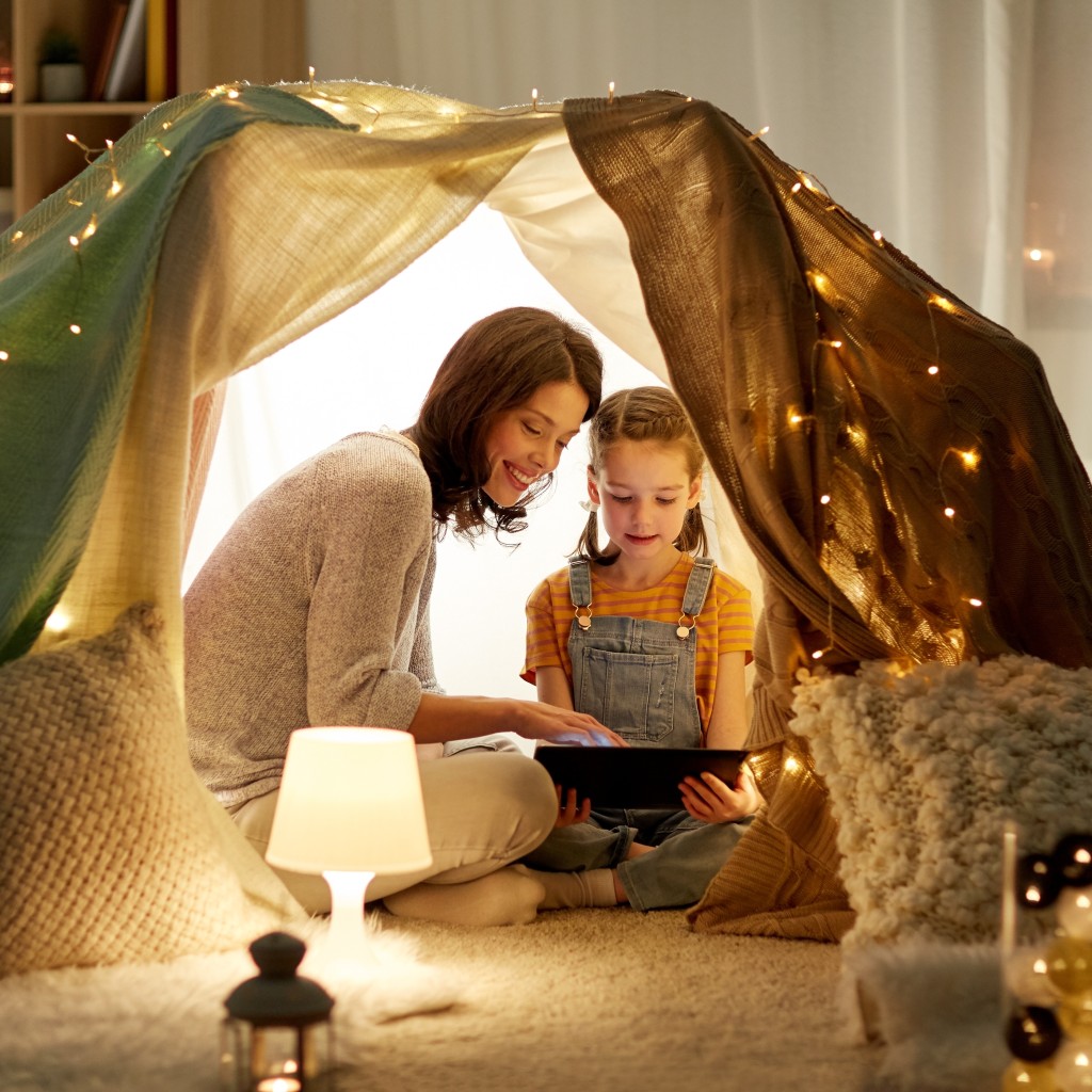 Mutter und Tochter sitzend in einem beleuchteten Zelt.