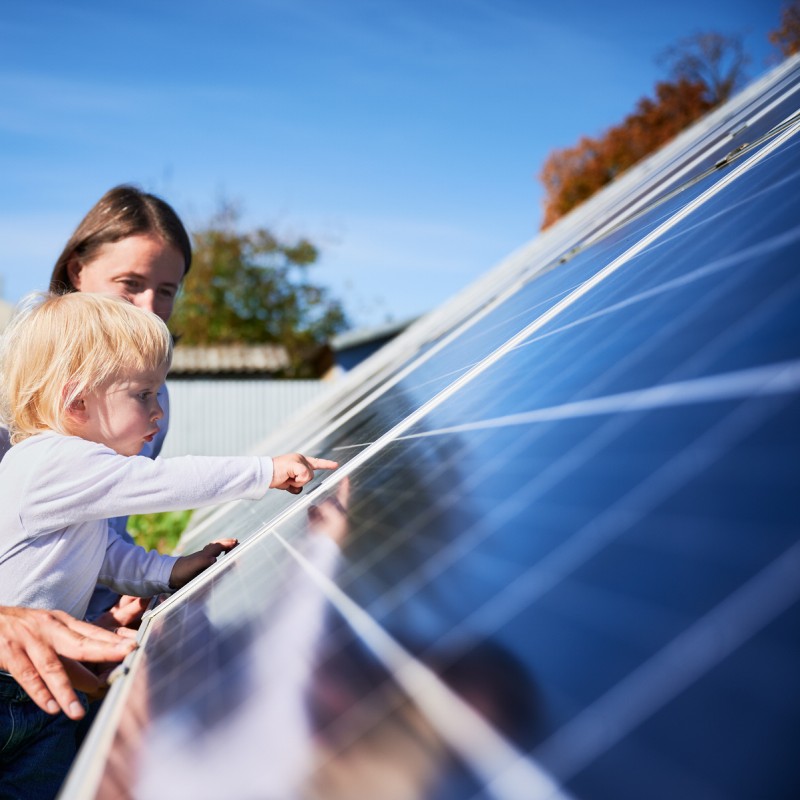 Familie an einem Solarpanel.