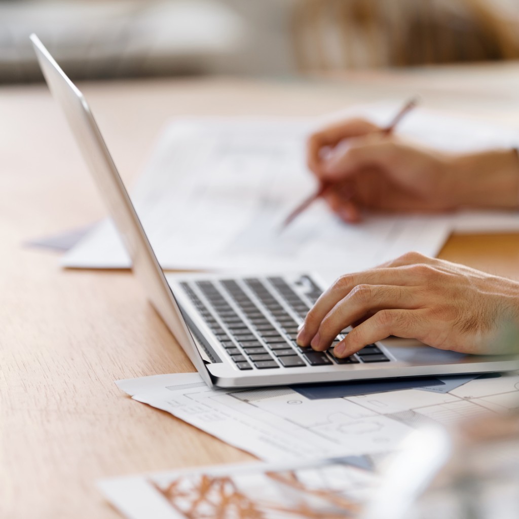 Laptop auf dem Tisch. Mann arbeitet daran.